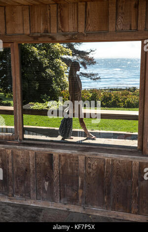 Usa, Kalifornien, Big Sur, Esalen, eine Reflexion von einer Frau zu Fuß vor der Buchhandlung mit dem Pazifischen Ozean in der Ferne, die esalen Institut Stockfoto