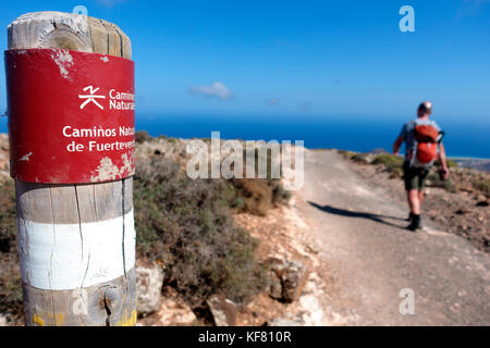 Mann, der an einer Wegmarkierung auf dem Weg zum Gipfel des Pico de la Zarza auf Fuerteventura vorbeigeht Stockfoto