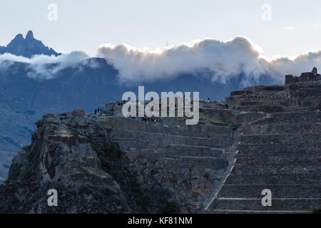 Menschen zu Fuß auf den Terrassen der pumatallis, alten Inka Festung und Berge in Wolken, das heilige Tal, Ollantaytambo, Peru Stockfoto