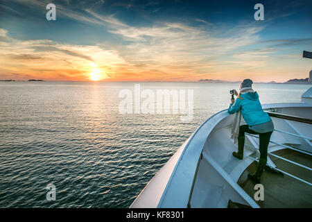 Kanada, Vancouver, British Columbia, weiblichen Passagier genießen Sie die Aussicht bei Sonnenuntergang der Discovery Passage in der Inside Passage, Holland Amerika Kreuzfahrt Stockfoto