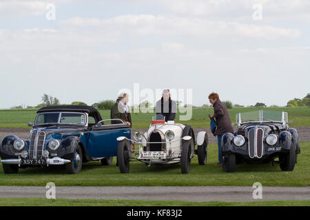Fahrer von zwei klassischen BMWs und einem Busfahrer treffen sich auf einem Clublauf Stockfoto