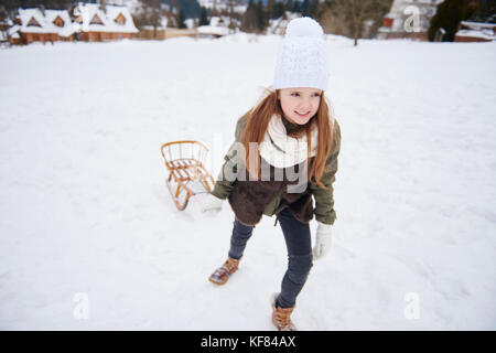 Kleine Mädchen spielen in schneereichen Winter Ort Stockfoto