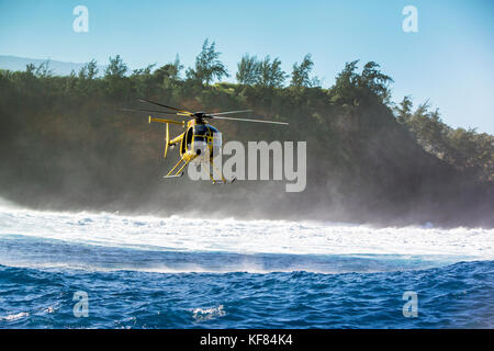 Usa, Hawaii, Maui, Backen, einem schwebenden Hubschrauber über den großen Wellen und Surfer an peahi auf dem northshore Stockfoto