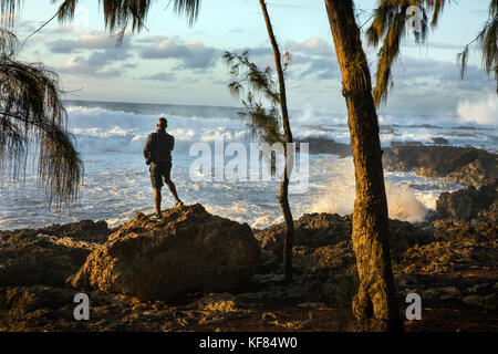 Hawaii, Oahu, North Shore, Umstehende sehen Sie eine große Rolle in Schwellen bei Sonnenuntergang an pupukea Beach Park an der Nordküste Stockfoto