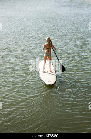Hawaii, Oahu, North Shore, eine junge Frau paddleboards auf der anahulu Fluss unterhalb des historischen Rainbow Bridge in der Stadt haliewa Stockfoto