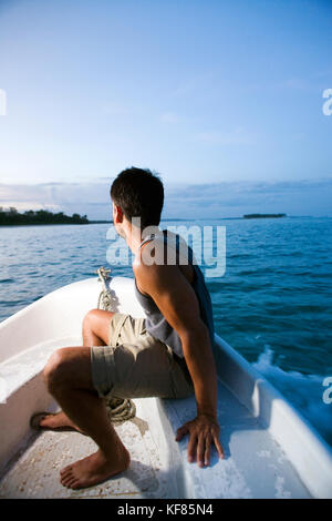 Indonesien, Mentawai Inseln, kandui Resort, Portrait von Mitte der erwachsenen Mann in einem kleinen Boot in der Dämmerung unterwegs Stockfoto