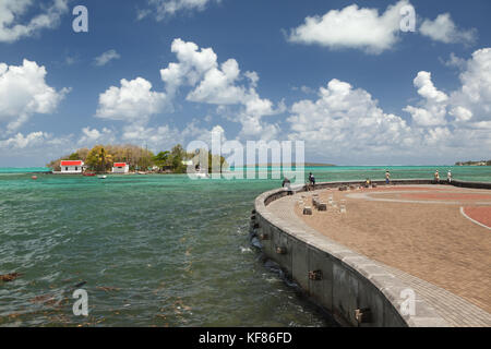 Mauritius, Fischer auf einem Stein Pier in Pattaya an der Wasserfront, Ile mouchoire Rouge in der Ferne Stockfoto