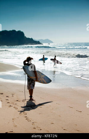 Mexiko, San Pancho, San Francisco, Surfer an der Wasserkante in San Pancho Strand Stockfoto