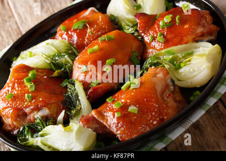 Gebratene Hühnerkeule mit pak Choy, Ingwer, Knoblauch und Frühlingszwiebeln closeup auf einem Teller. Horizontale Stockfoto