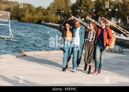 Multikulturelle Freunde gehen auf Pier Stockfoto