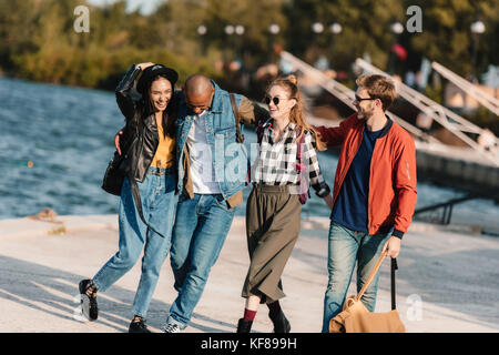 Multikulturelle Freunde gehen auf Pier Stockfoto