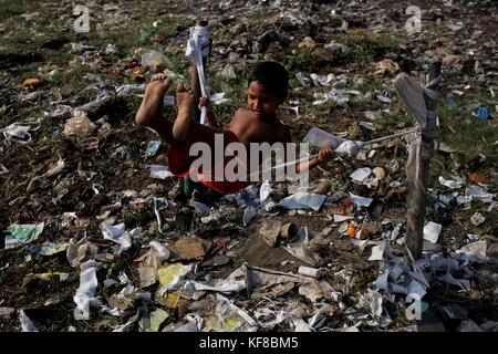 Dhaka, Bangladesch. 26 Okt, 2017. Ein Kind spielen, indem sie ein Seil auf einer staubigen Feld in die Ausgestoßenen von Dhaka. Credit: md. mehedi Hasan/Pacific Press/alamy leben Nachrichten Stockfoto