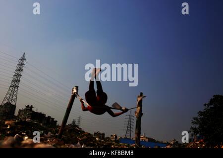 Dhaka, Bangladesch. 26 Okt, 2017. Ein Kind spielen, indem sie ein Seil auf einer staubigen Feld in die Ausgestoßenen von Dhaka. Credit: md. mehedi Hasan/Pacific Press/alamy leben Nachrichten Stockfoto