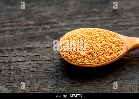 Senfkörner in hölzernen Löffel schließen Stockfoto