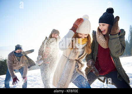 Jungen gegen Mädchen an der Schneeballschlacht Stockfoto