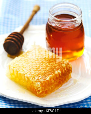 Waben mit Honig, honig in Glas und Holz- Honig Pendelarm auf Platte Stockfoto