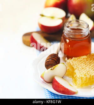 Waben mit Honig, honig in Glas und Scheiben von reife Äpfel auf Platte Stockfoto