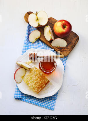 Waben mit Honig, honig in Glas und Scheiben von reife Äpfel auf Platte Stockfoto