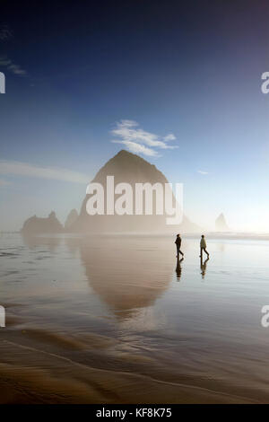 Usa, Oregon, Pacific City, Personen entlang der pazifischen Strand der Stadt mit Haystack Rock in der Ferne Stockfoto