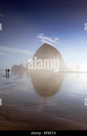 Usa, Oregon, Pacific City, Personen entlang der pazifischen Strand der Stadt mit Haystack Rock in der Ferne Stockfoto