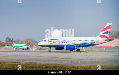 Mailand Linate, Italien - 25. Oktober 2017: Ein Airbus A320-200 von British Airways fährt am Flughafen Linate mit einem Alitalia-Flugzeug im Hintergrund Stockfoto
