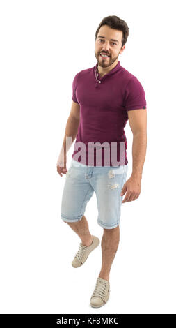 Voller Körper portrait. netter Mann zu Fuß. Schöne und bärtige Person. Er trägt ein magenta Polo Shirt und Shorts Jeans. weißer Hintergrund, isoliert. Stockfoto