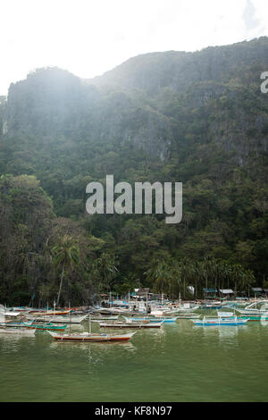 Philippinen, palawan El Nido, Fischerboote sind unter dem Dschungel in die Stadt El nido verankert, in bacuit Bay in das Südchinesische Meer Stockfoto