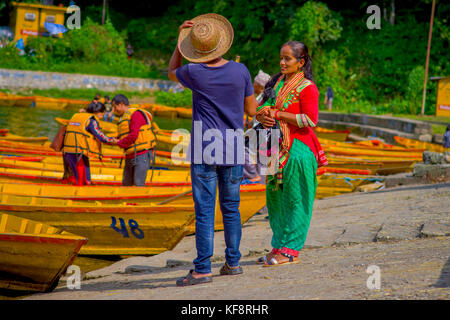 Pokhara, Nepal - November 04, 2017: nicht identifizierte Frau im Gespräch mit einem Reiseführer mit einige Boote in begnas See in Pokhara, Nepal Stockfoto