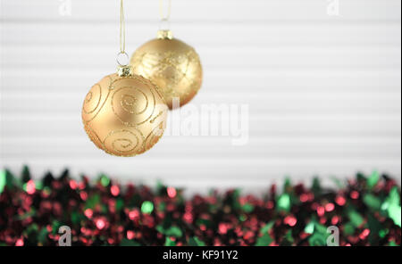 Weihnachten fotografie Bild von Xmas Tree Dekoration zum Aufhängen von Runden gold glitzer Weihnachtskugel mit farbigen rot grün Lametta und weißem Holz Hintergrund Stockfoto