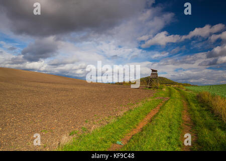 Huntig Turm auf der leeren Straße zwischen den Feldern im Böhmischen Mittelgebirge, Tschechische Republik Stockfoto