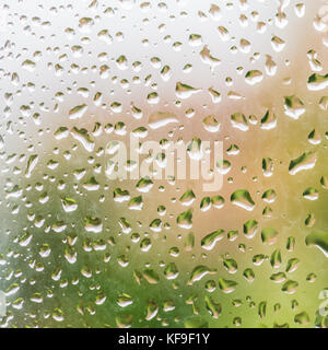 Eine Makroaufnahme von einigen Regentropfen auf eine Glasscheibe. Stockfoto