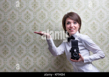 Vintage Fotograf zeigt einige Copyspace in der Hand vor einem vintage Hintergrund Stockfoto