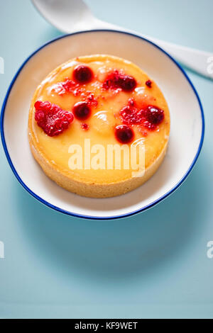 Lemon tart mit roten Früchten auf der blauen Fläche Stockfoto