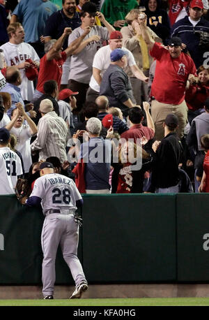 Ein Fan im linken Feld hält einen großen Slam-Ball, den er gegenüber dem linksfeldspieler Raul Ibanez (28) der Seattle Mariners erwischte, dass Juan Rivera von Los Angeles Angels im vierten Inning eines Baseballspiels in Anaheim, Kalifornien, am Freitag, den 12. Mai 2006, den Mariners Pitcher Bobby Livingston traf. Foto von Francis Specker Stockfoto