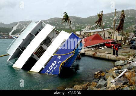 Beamte der US-Küstenwache inspizieren ein beschädigtes und teilweise versunkenes Boot während der Hilfsmaßnahmen nach dem 18. Oktober 2017 in Crown Bay, St. Thomas, US-amerikanische Jungferninseln. (Foto von Matthew S. Masaschi via Planetpix) Stockfoto