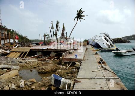 Beamte der US-Küstenwache inspizieren ein beschädigtes und teilweise versunkenes Boot während der Hilfsmaßnahmen nach dem 18. Oktober 2017 in Crown Bay, St. Thomas, US-amerikanische Jungferninseln. (Foto von Matthew S. Masaschi via Planetpix) Stockfoto