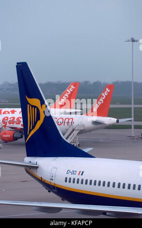 Schwanz eines Ryanair Boeing 737-800 mit zwei easyJet Airbus A319 auf dem Vorfeld hinter geparkt Stockfoto