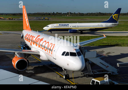 Eine easyJet Airbus A319-100 mit Ryanair Boeing 737-800 Rollens und Bagger und Baufahrzeuge hinter Stockfoto