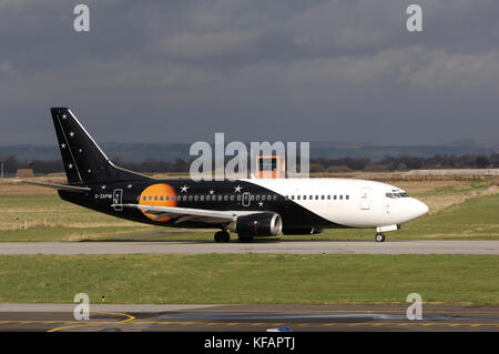 Ein Titan Airways Boeing 737-300 das Rollen mit dunklen Wolken und Control-Tower hinter Stockfoto