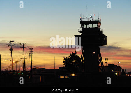 Air Traffic Control Tower in der Abenddämmerung mit Licht Ein, grün drehen - Rundumleuchte und Telegrafenmasten Stockfoto