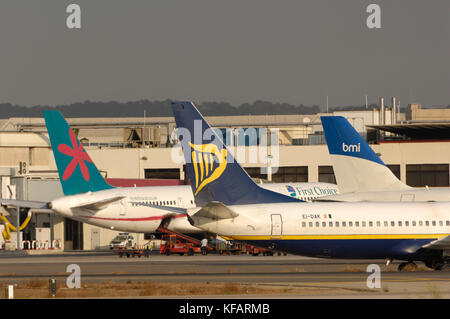 Schwanz-Flossen von Ryanair Boeing 737-800 mit First Choice Airways757-200 und BMI British Midland International Airbus A320-200 am Terminal beh geparkt Stockfoto