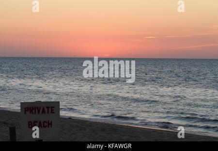 Sonnenuntergang auf Cape Cod Bay bei Linnell Landing Beach, Brewster, Massachusetts, mit Veröffentlicht 'Privatstrand'-Zeichen im Vordergrund. Stockfoto