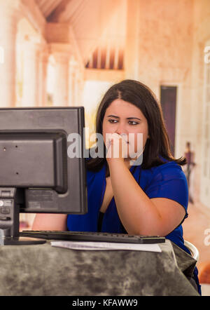 Portrait von besorgt fette Frau Arbeiten am Laptop sitzen vor Ihrem Schreibtisch im Büro Stockfoto