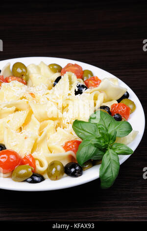 Pasta mit Olivenöl, Knoblauch, Basilikum und Tomaten und gewürzt mit Parmesan. Stockfoto