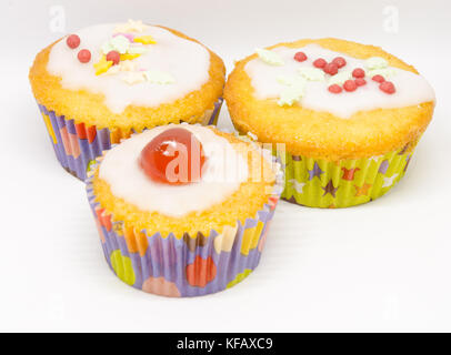 Eine Nahaufnahme eines hausgemachten Cupcakes mit Zuckerglasur, Gletscher Kirschen und Streuseln. Stockfoto