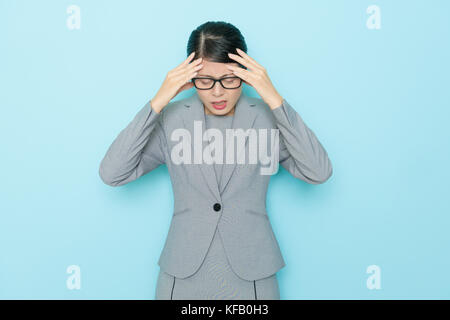 Schönheit elegante Rechtsanwalt Frau, arbeiten Problem und ein ungutes Gefühl, weil sie Kopfschmerzen auf blauem Hintergrund isoliert. Stockfoto