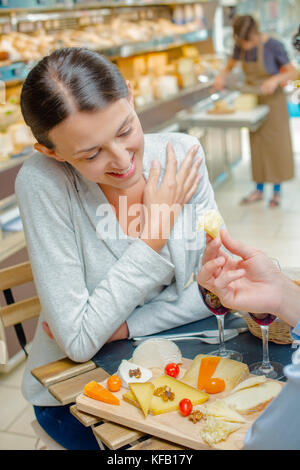 Dame in Essen, Käse angeboten wird Stockfoto