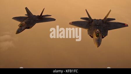 Zwei taktische Kampfflugzeuge der US Air Force F-22 Raptor fliegen bei Sonnenuntergang am 21. August 2012 über New York in Formation. (Foto von Kenneth W. Norman über Planetpix) Stockfoto