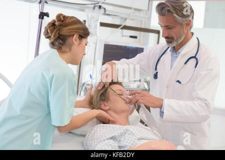 Arzt, der sauerstoffmaske Patientin im Krankenhaus Stockfoto