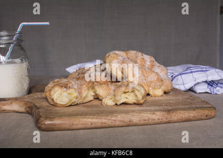 Hausgemachtes Gebäck, süße Brötchen mit Kokos Chips und Milch Stockfoto